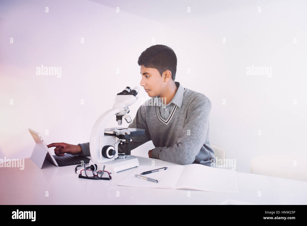 Fidji Indian boy using digital tablet and microscope Banque D'Images