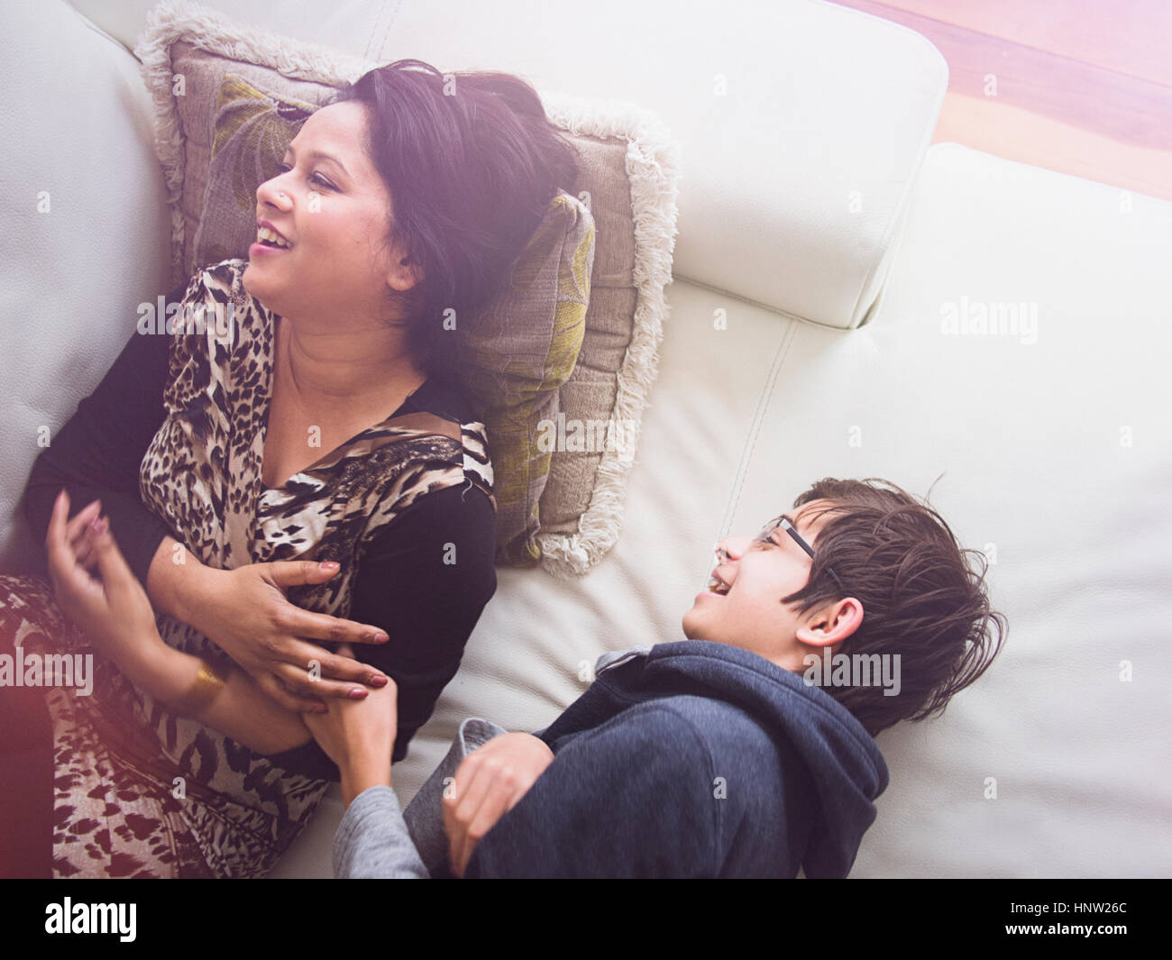 La mère et le fils portant sur le canapé et de rire Banque D'Images