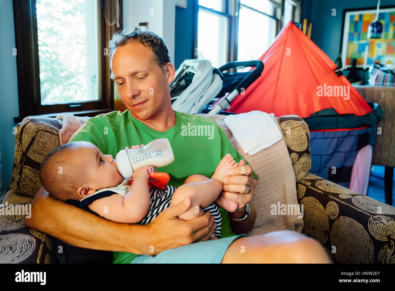 Père holding baby son boire du lait en bouteille Banque D'Images