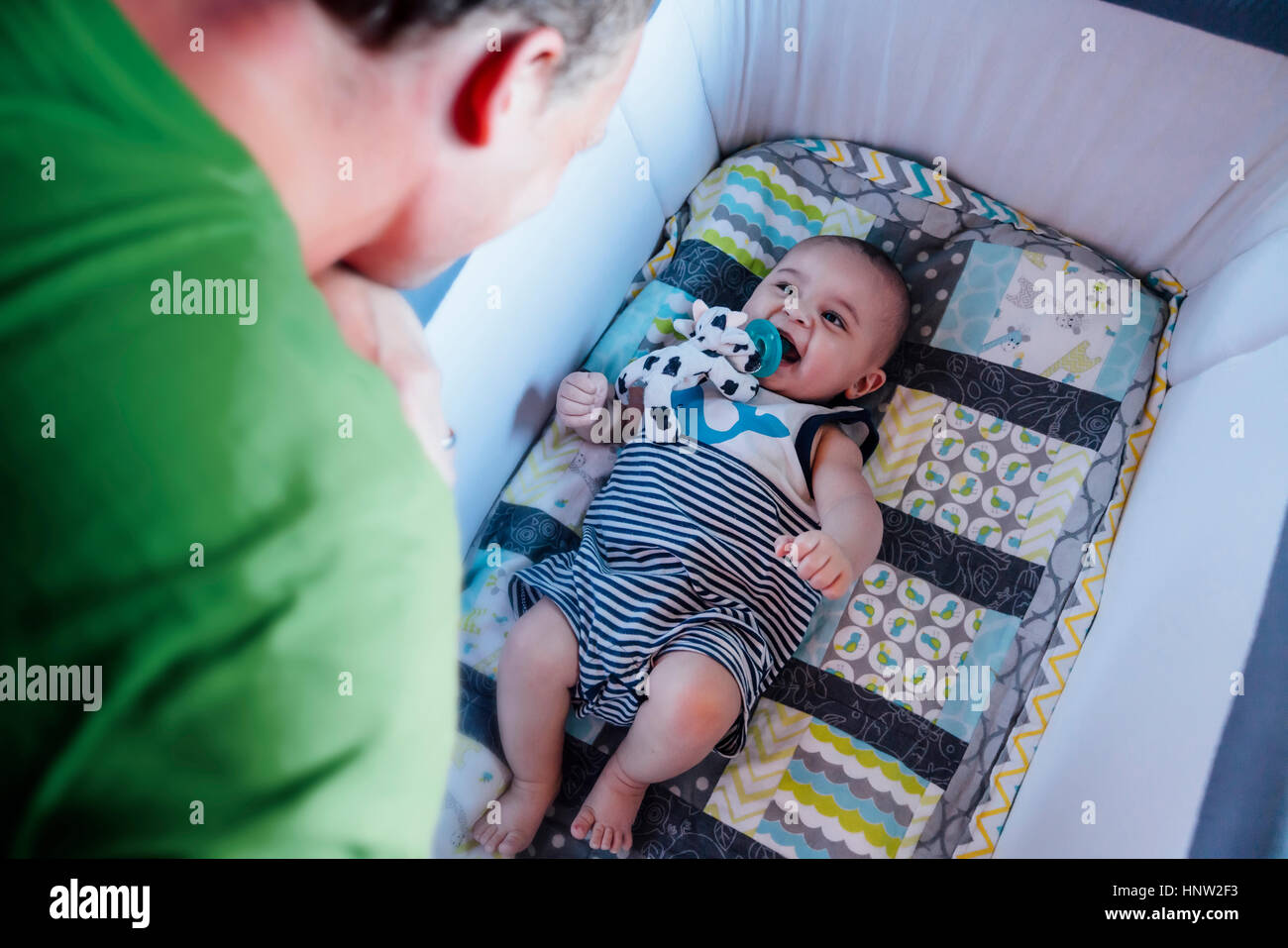 Père regardant bébé dans lit-bébé Banque D'Images