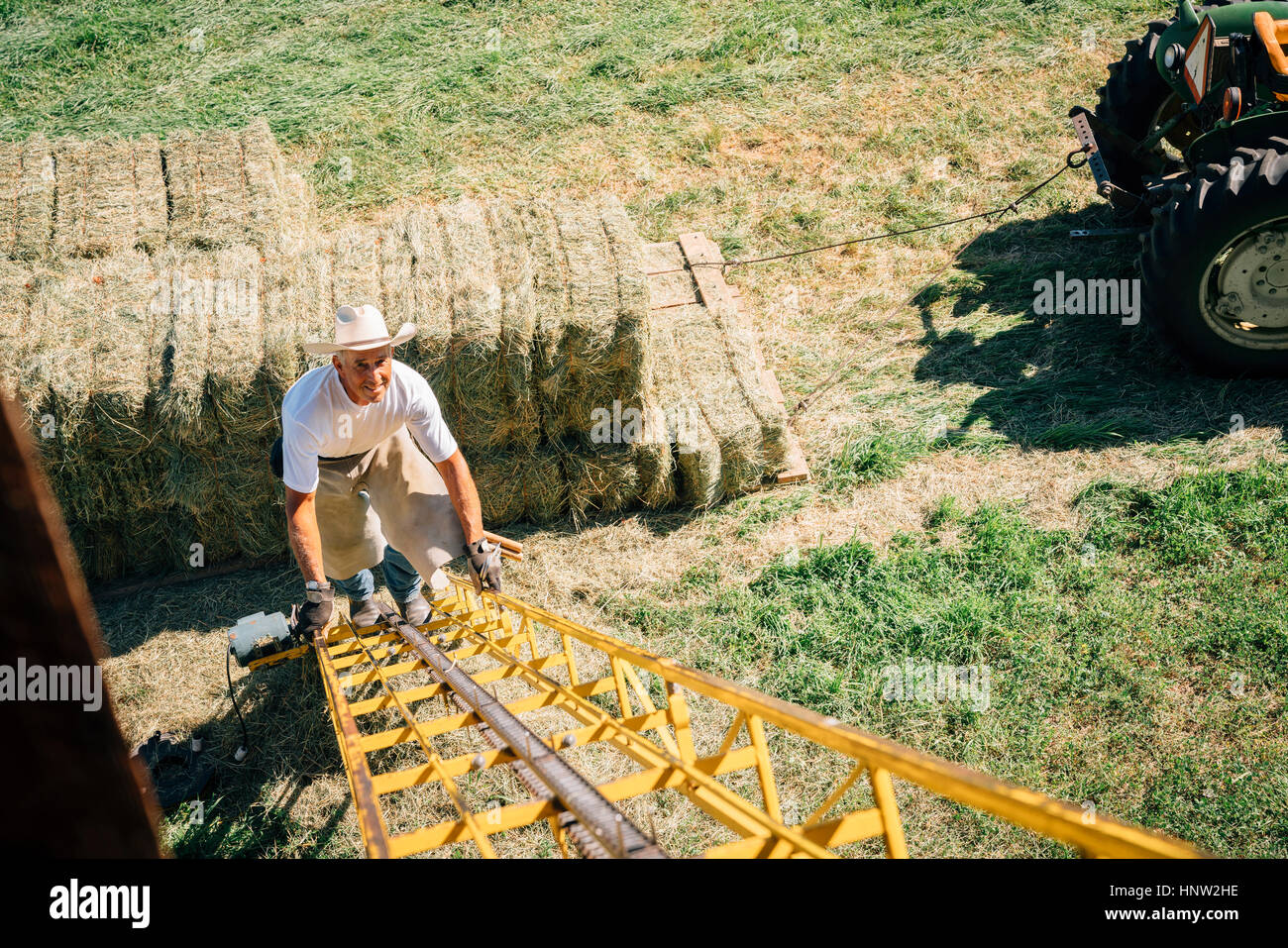 Caucasian farmer climbing ladder à barn Banque D'Images