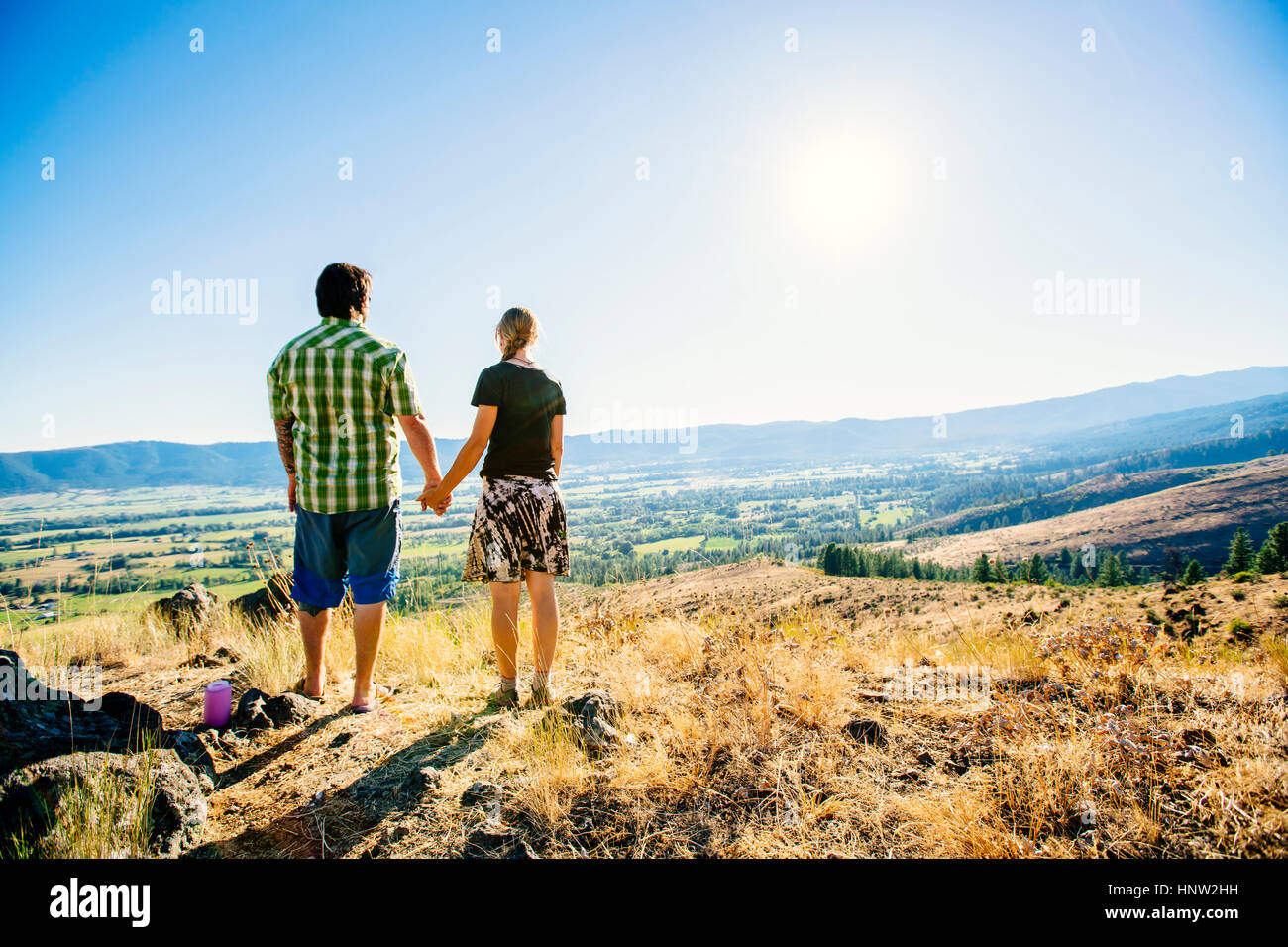 Caucasian couple standing on hill holding hands Banque D'Images