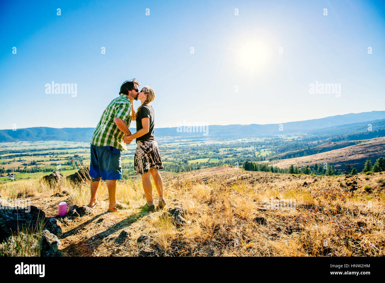 Caucasian couple standing on hill et les baisers Banque D'Images