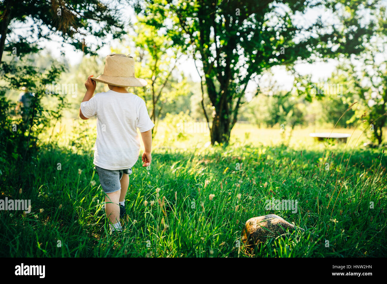Woman wearing hat walking in grass Banque D'Images