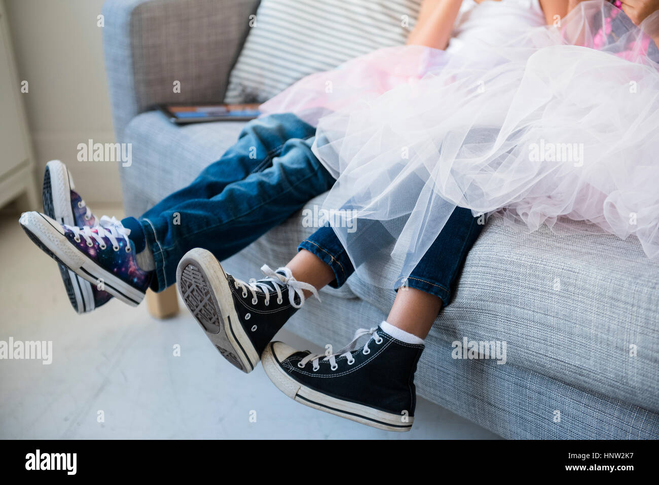 Les jambes des filles portant des tutus sur canapé Banque D'Images