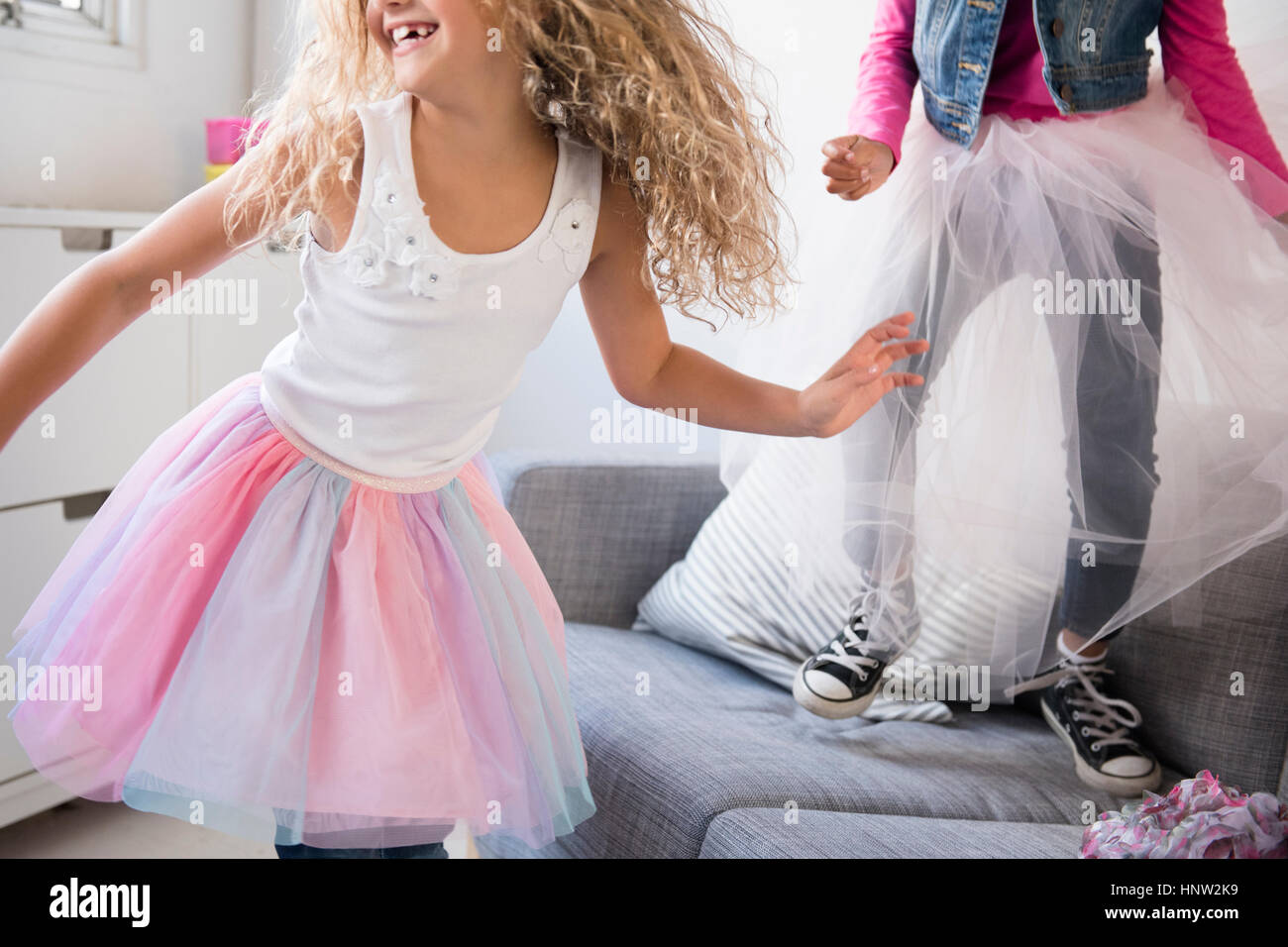 Les jeunes filles portant des tutus danse sur canapé Banque D'Images