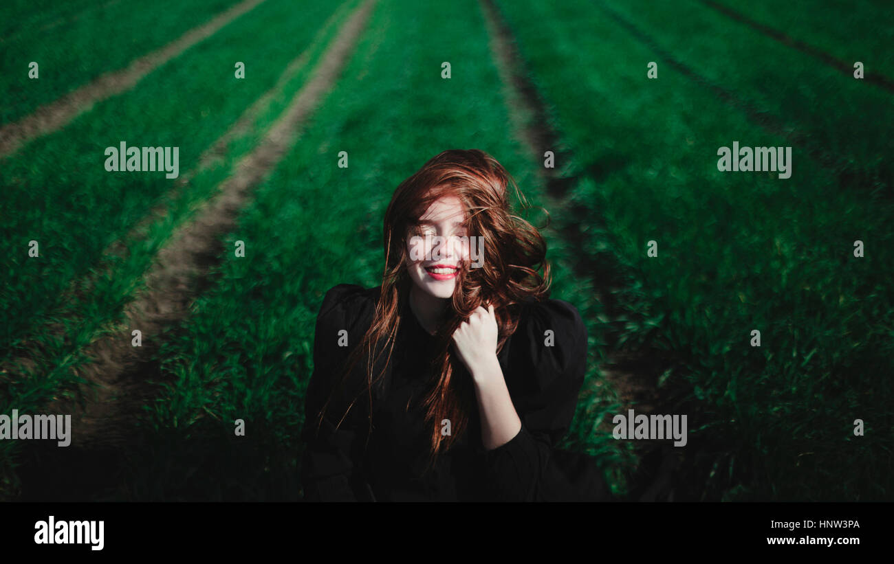 Smiling Caucasian woman en lignes d'herbe Banque D'Images