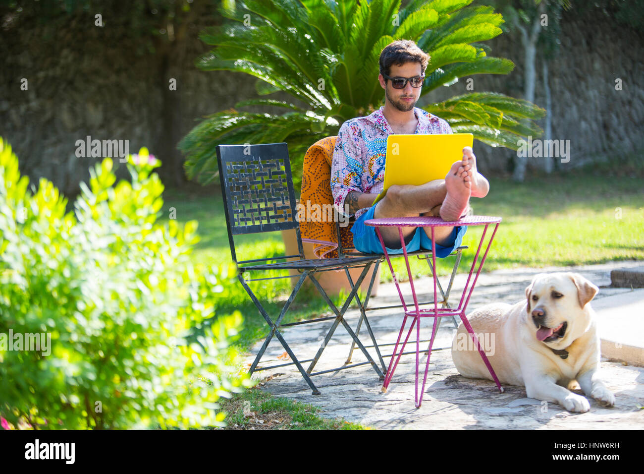 L'homme avec les pieds jusqu'à l'aide d'un ordinateur portable Banque D'Images