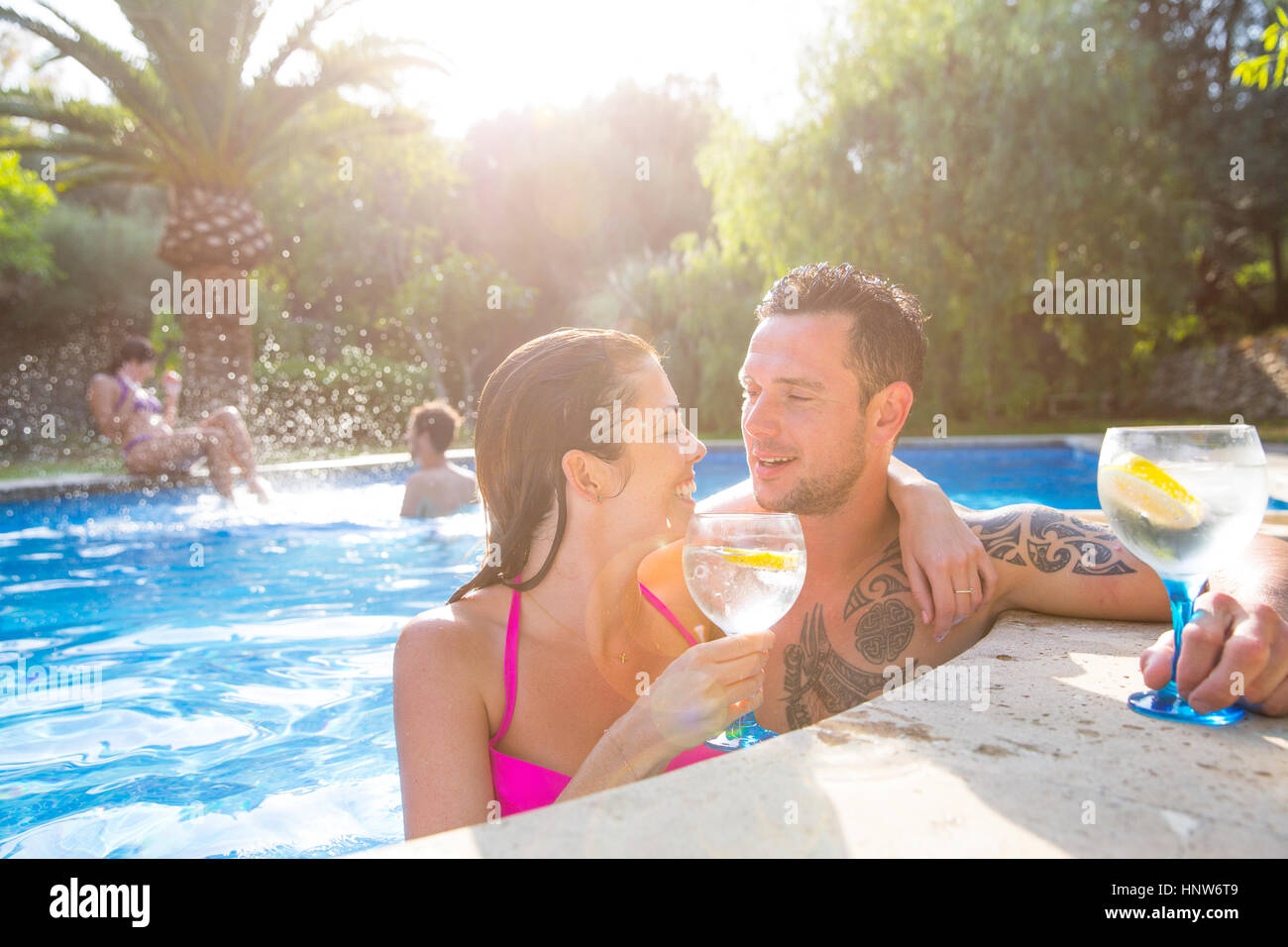 Couple dans une piscine en dégustant une boisson Banque D'Images