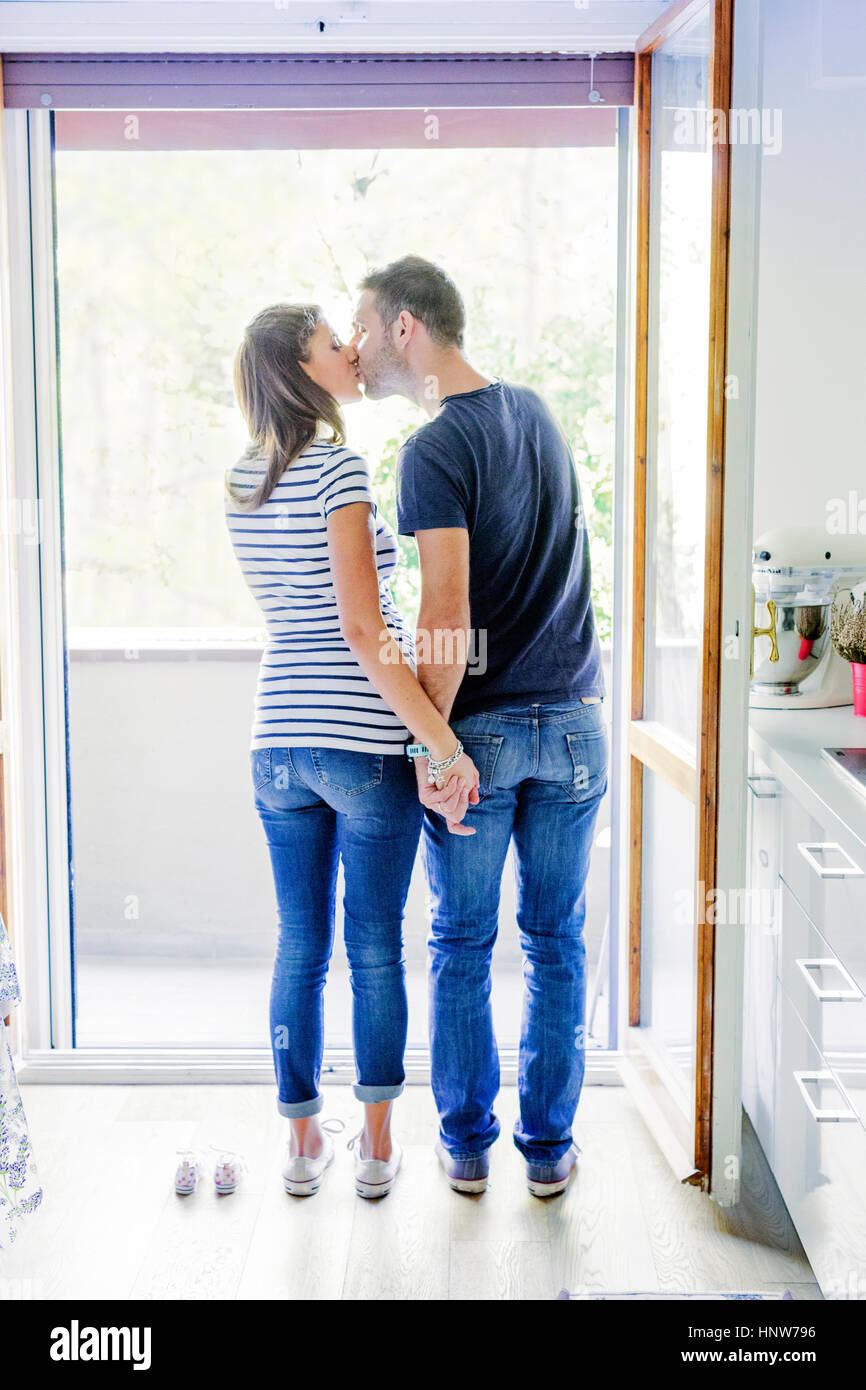 Vue arrière du couple par les chaussons bébé kissing Photo Stock - Alamy