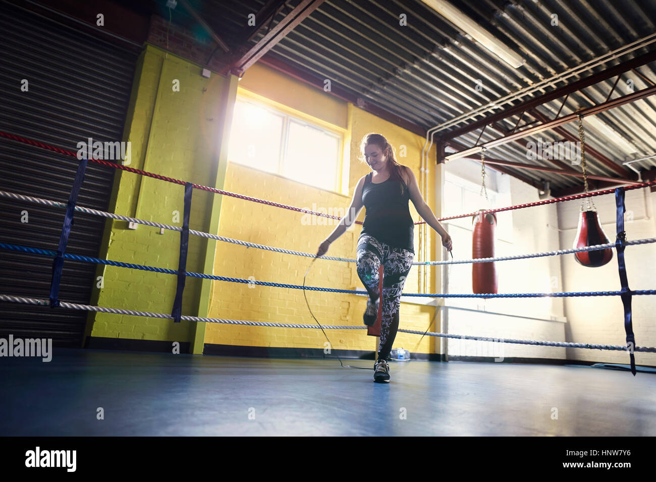 Young female boxer sautant en ring de boxe Banque D'Images