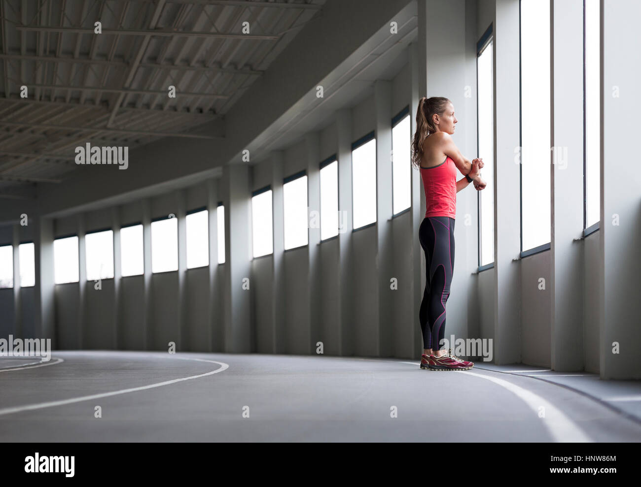 Femme en environnement urbain, à la fenêtre, à travers l'étirement Banque D'Images