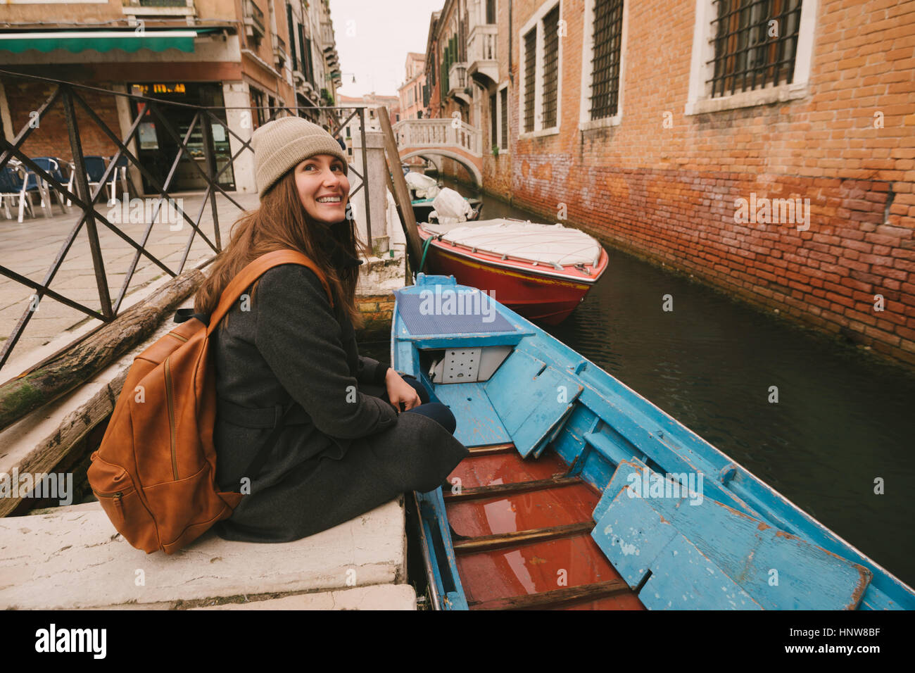 Femme assise par canal, Venice, Italie Banque D'Images