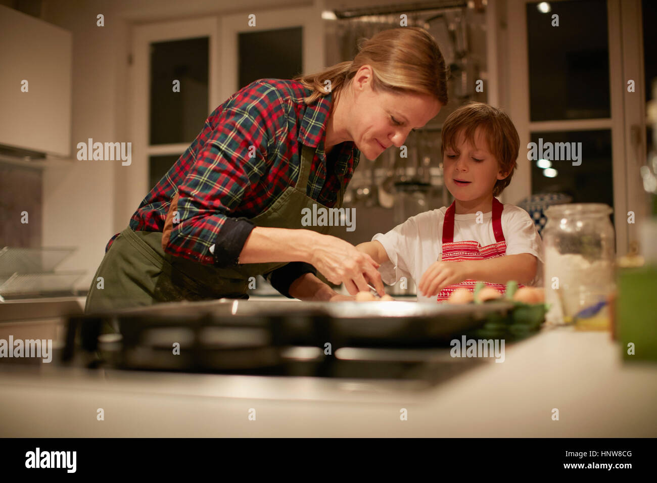 Young woman helping son avec du bicarbonate sur compteur de cuisine Banque D'Images