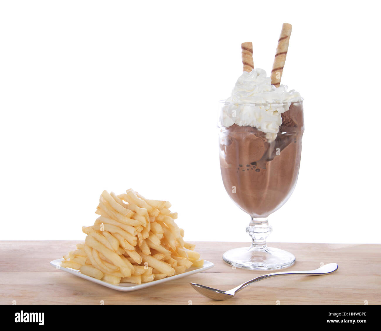 Glace au chocolat en verrines de crème fouettée et carré blanc plat de frites empilés sur une table en bois clair. Mode passagère ou nouvelle tendance de l'alimentation. Banque D'Images
