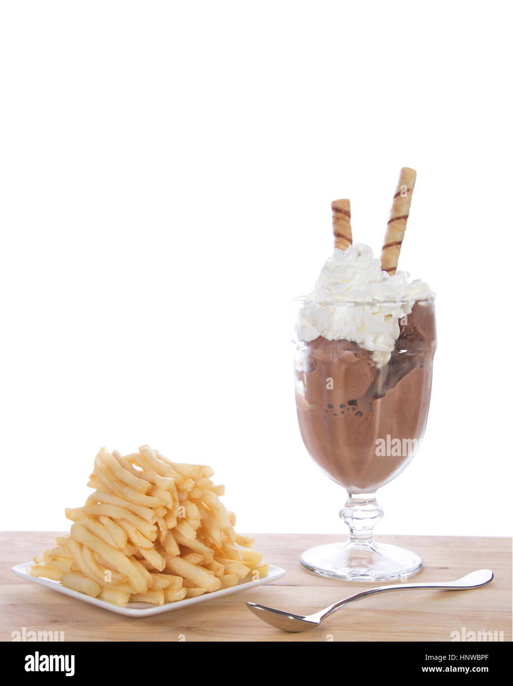 Glace au chocolat en verrines de crème fouettée et carré blanc plat de frites empilés sur une table en bois clair. Mode passagère ou nouvelle tendance de l'alimentation. Banque D'Images