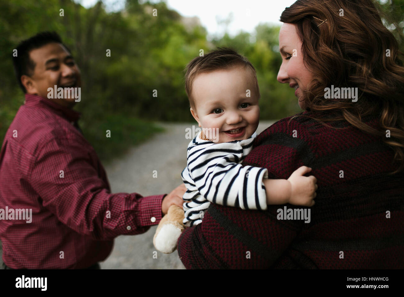 Baby Boy in mother's arms looking at camera smiling Banque D'Images