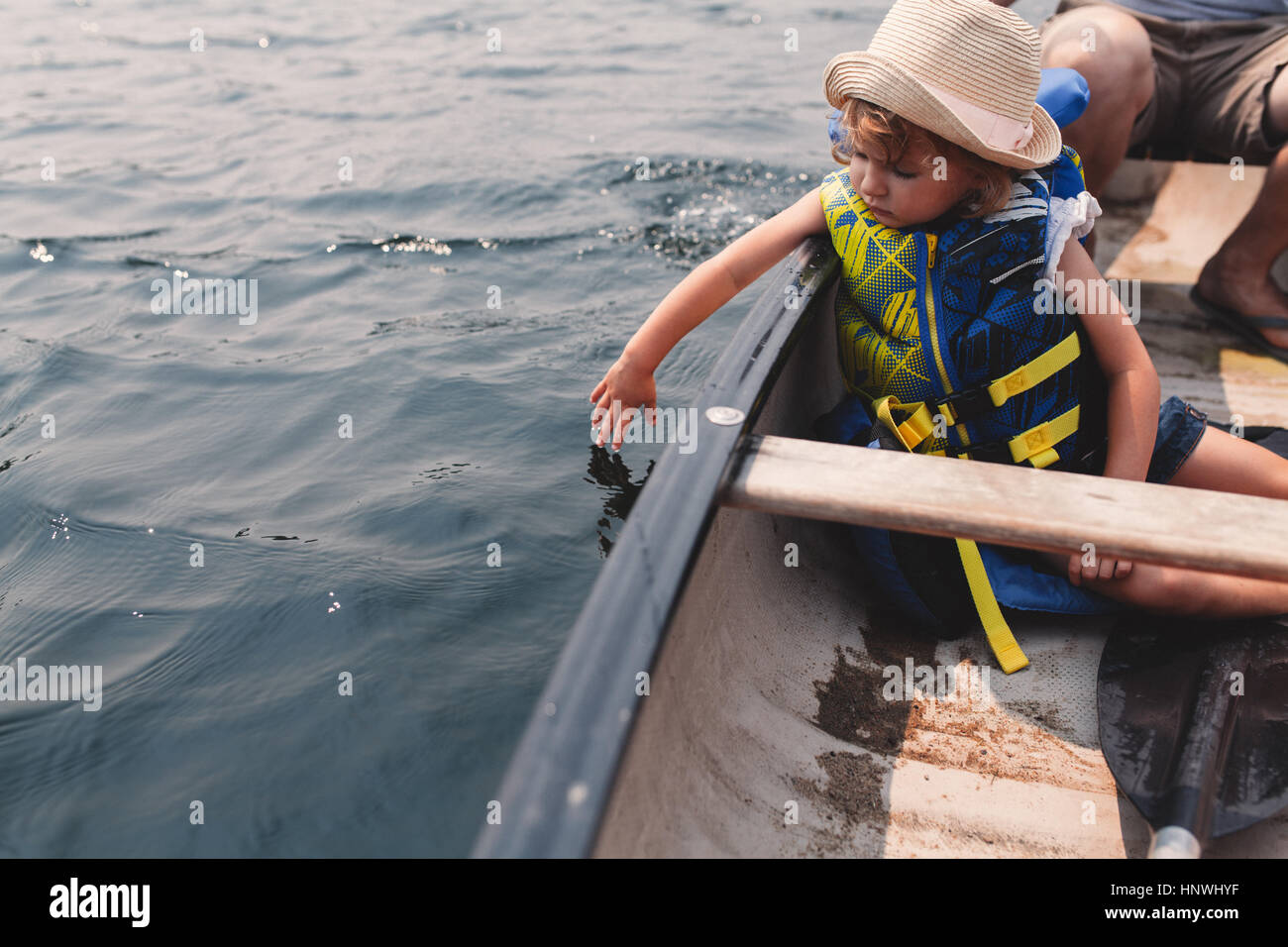 Fille de l'eau touchant de bateau à rames sur le lac Banque D'Images