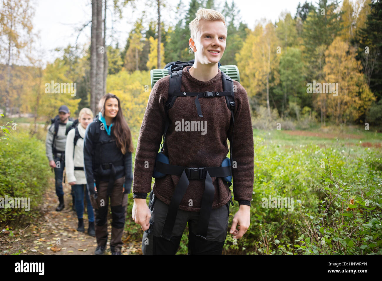 Smiling man avec les amis de la randonnée sur sentier forestier Banque D'Images