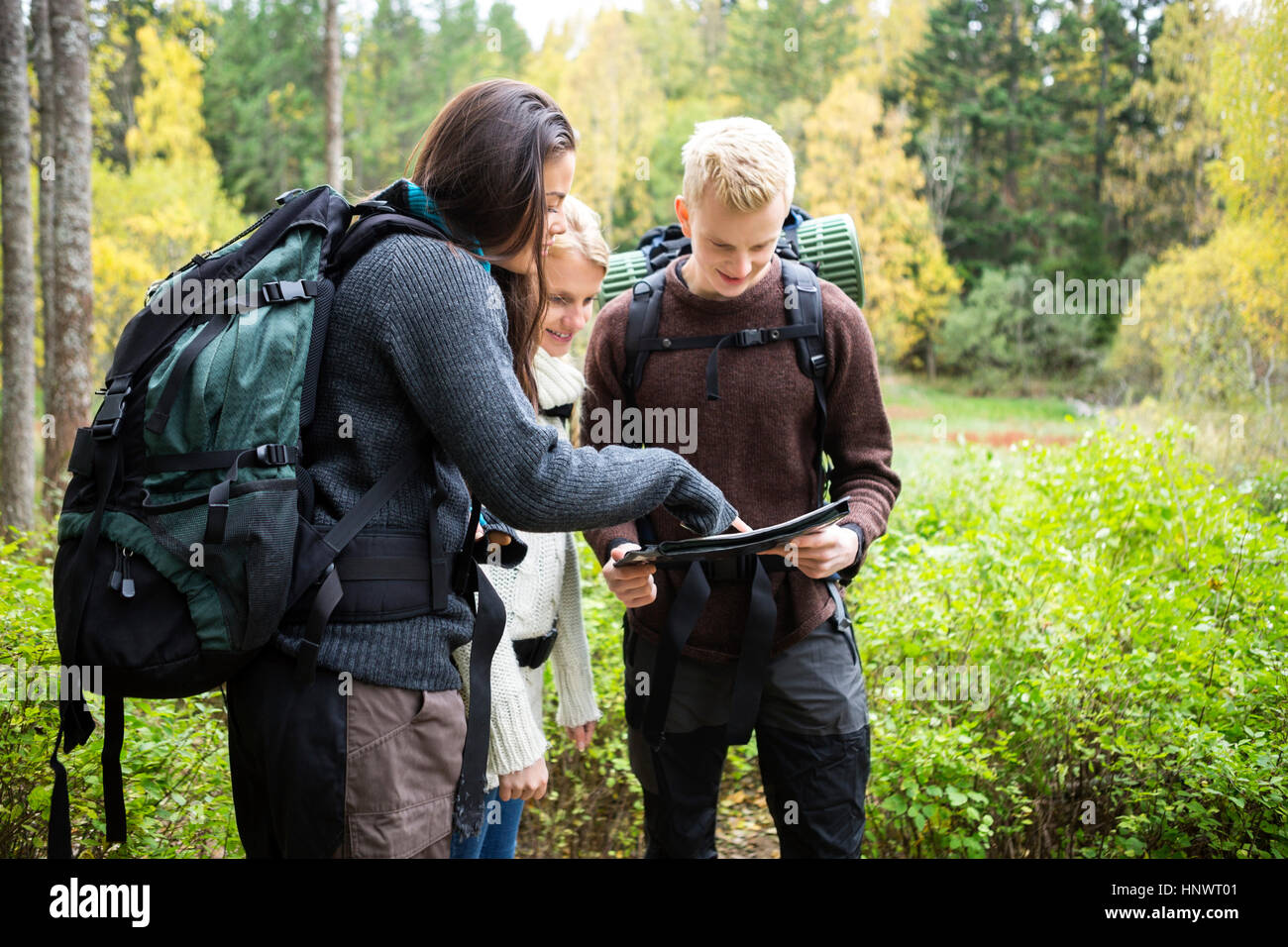 Les jeunes randonneurs contrôle map in forest Banque D'Images