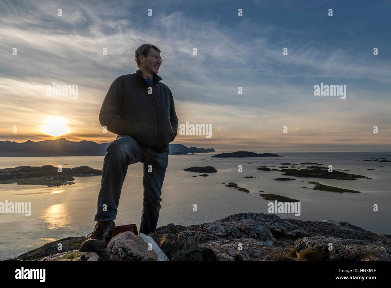 Man climbing un sommet sur l'île de Kvaloya en automne, la Norvège arctique Banque D'Images