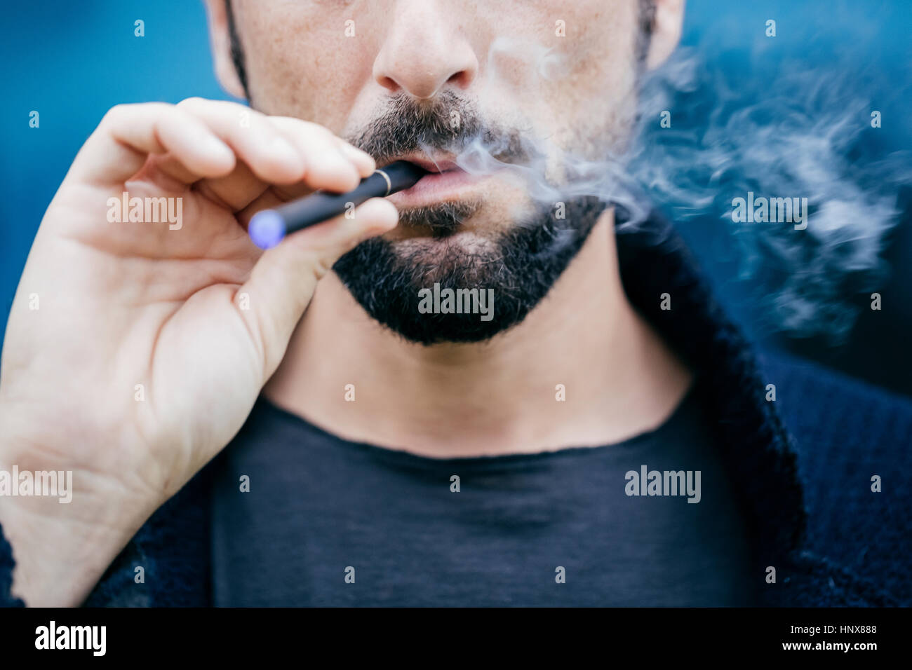 Portrait d'homme qui fume une cigarette électronique Banque D'Images