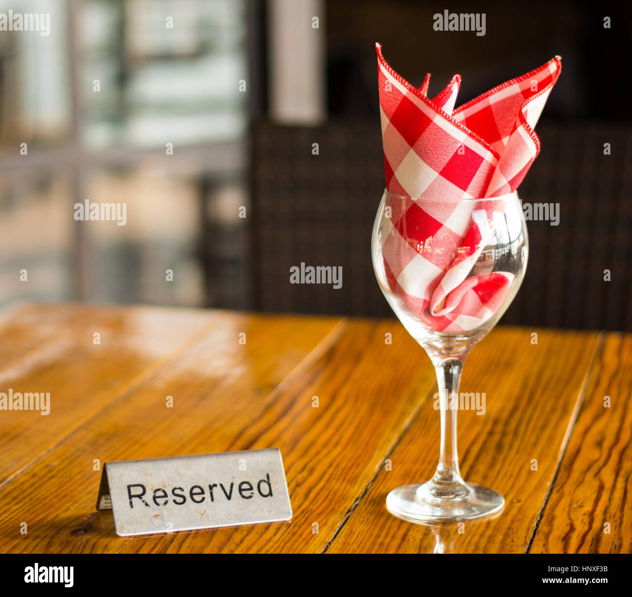 Réservés signe avec un verre de vin sur la table en bois Banque D'Images