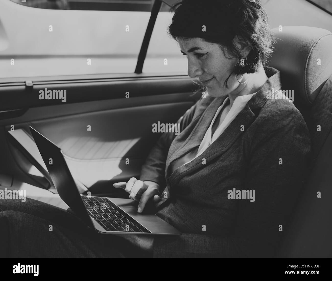 Woman Using Laptop voiture à l'intérieur Banque D'Images
