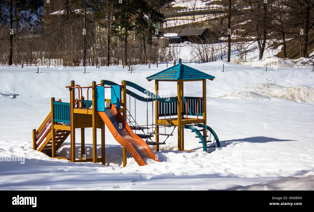 Les jeux pour les enfants, isolés dans un parc avec de la neige Banque D'Images