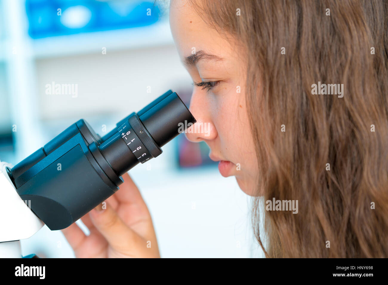 Fille en classe avec microscope biologique recherche Banque D'Images