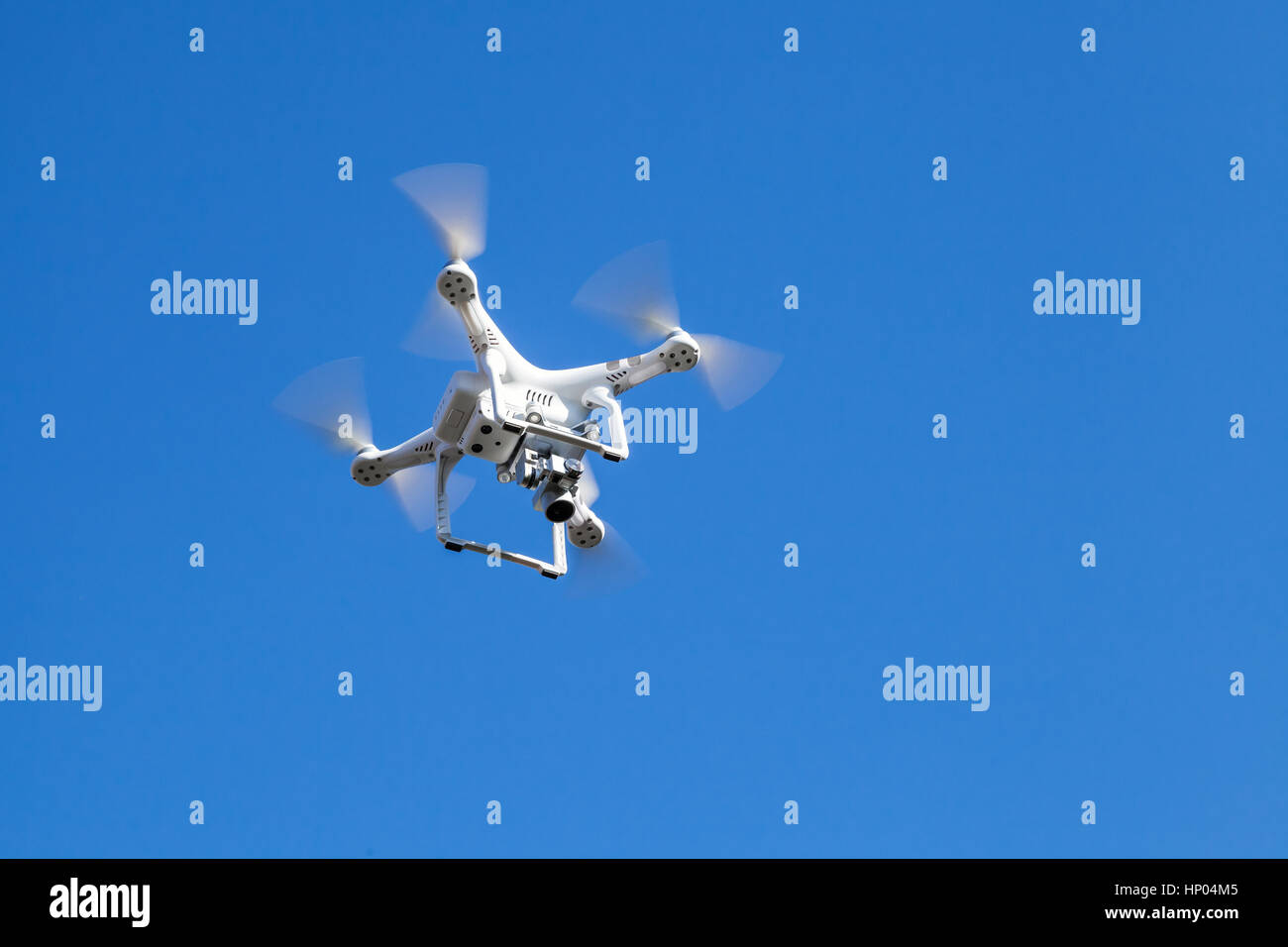 Quadrocopter blanc dans le ciel bleu, drone compact contrôlé par une télécommande sans fil Banque D'Images