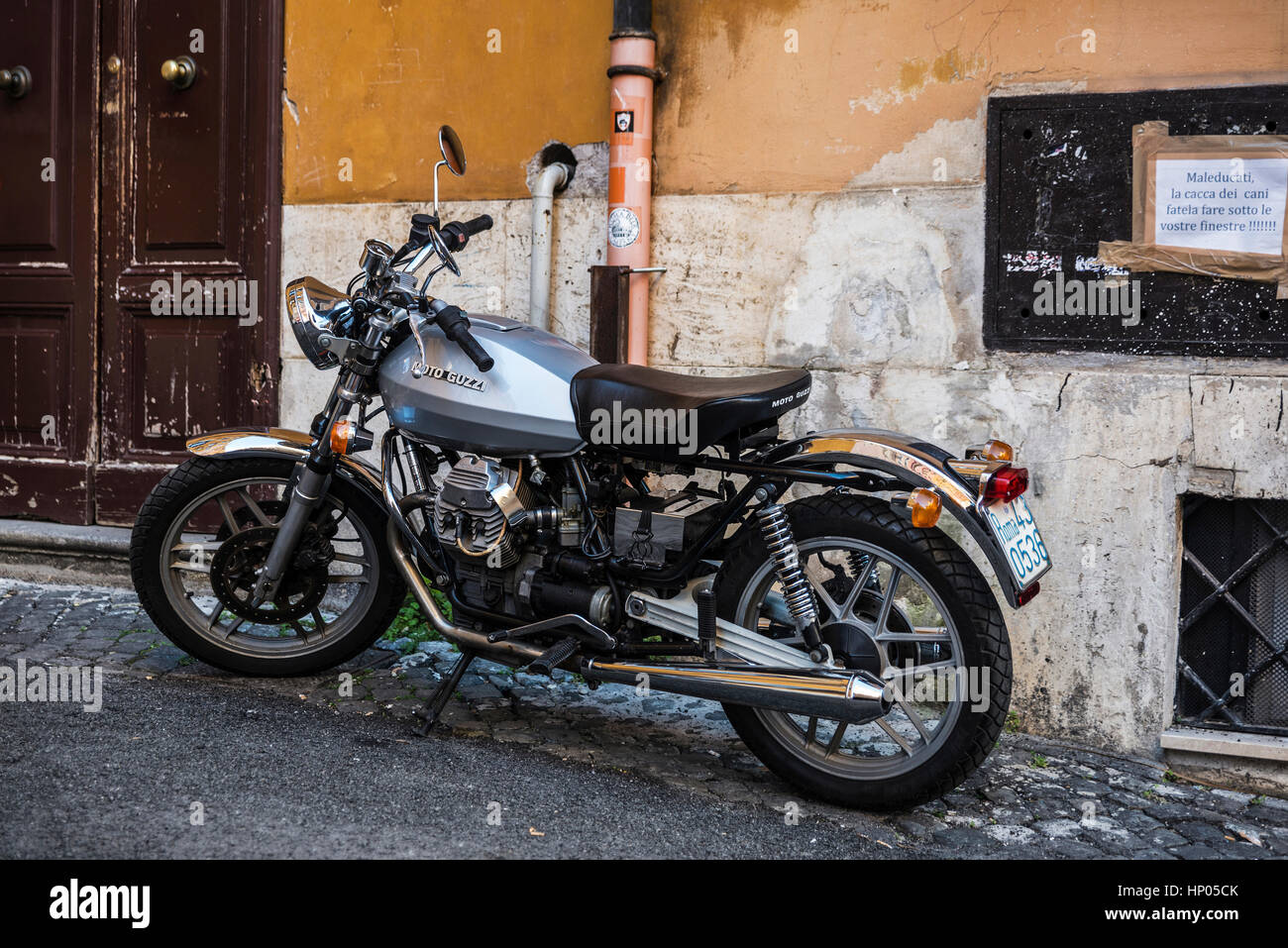 Rome, Italie - 30 Décembre, 2016 Moto Guzzi : stationné dans le centre historique de Rome avec une affiche de plainte pour l'excrément de chien Banque D'Images