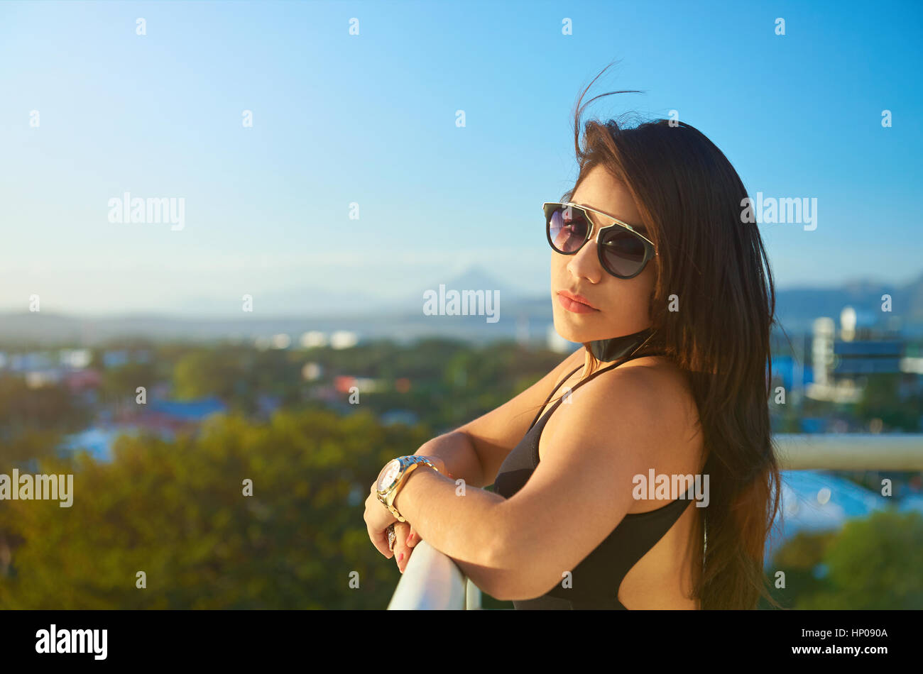 Portrait de jeune femme brune avec des lunettes de soleil en tenue  d'arrière-plan de la ville Photo Stock - Alamy