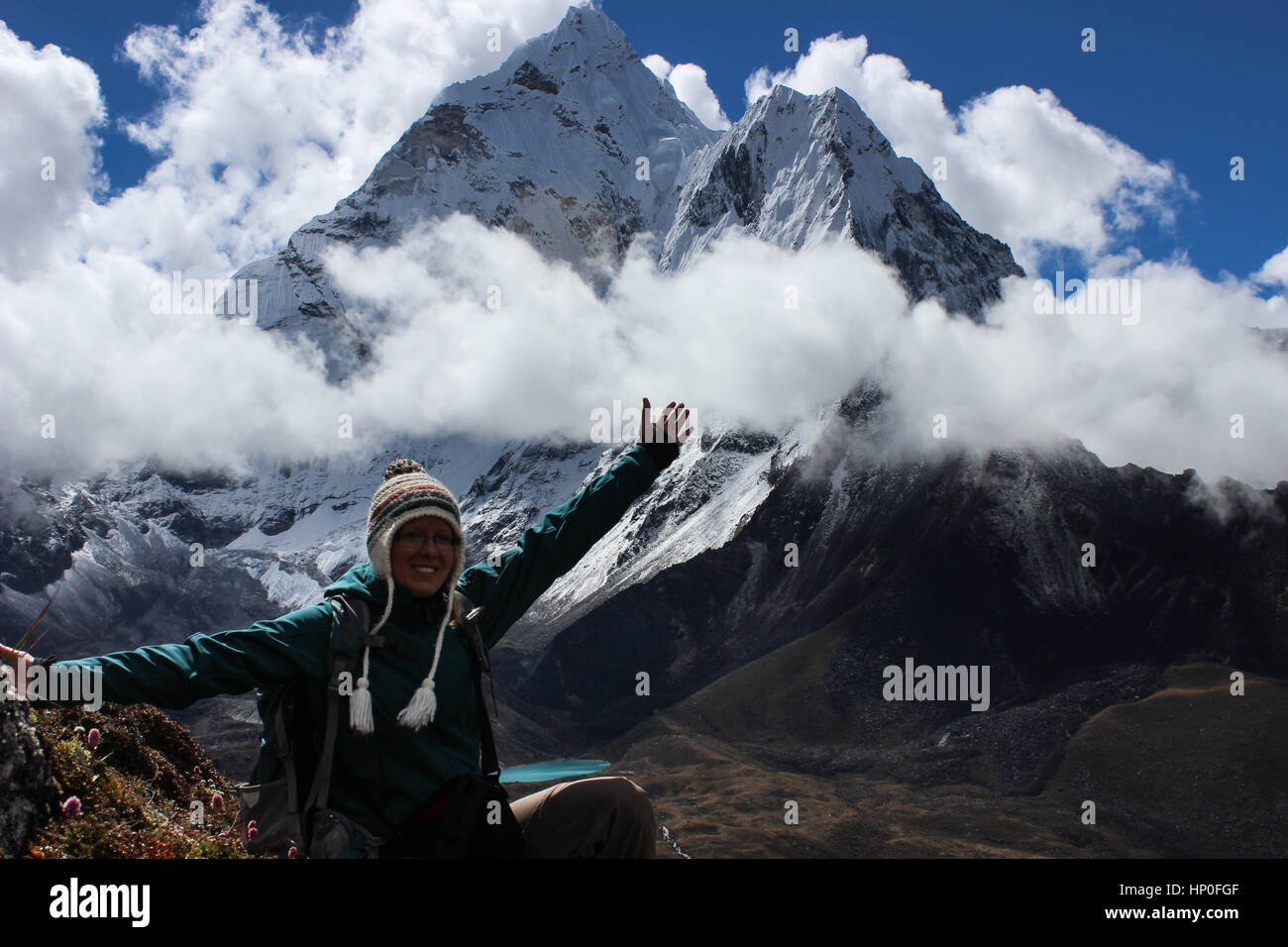 Heureux, smiling girl avec de hautes montagnes et nuages dans l'arrière-plan Banque D'Images