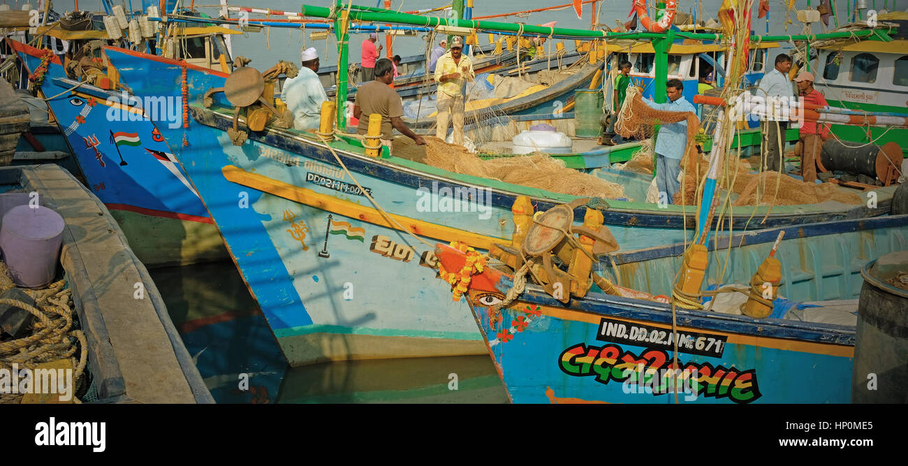 Moustiquaires sont vérifiés à bord de bateaux de pêche au port sur l'île de Diu, Inde. La pêche dans la mer d'Oman est un pilier de l'économie locale Banque D'Images