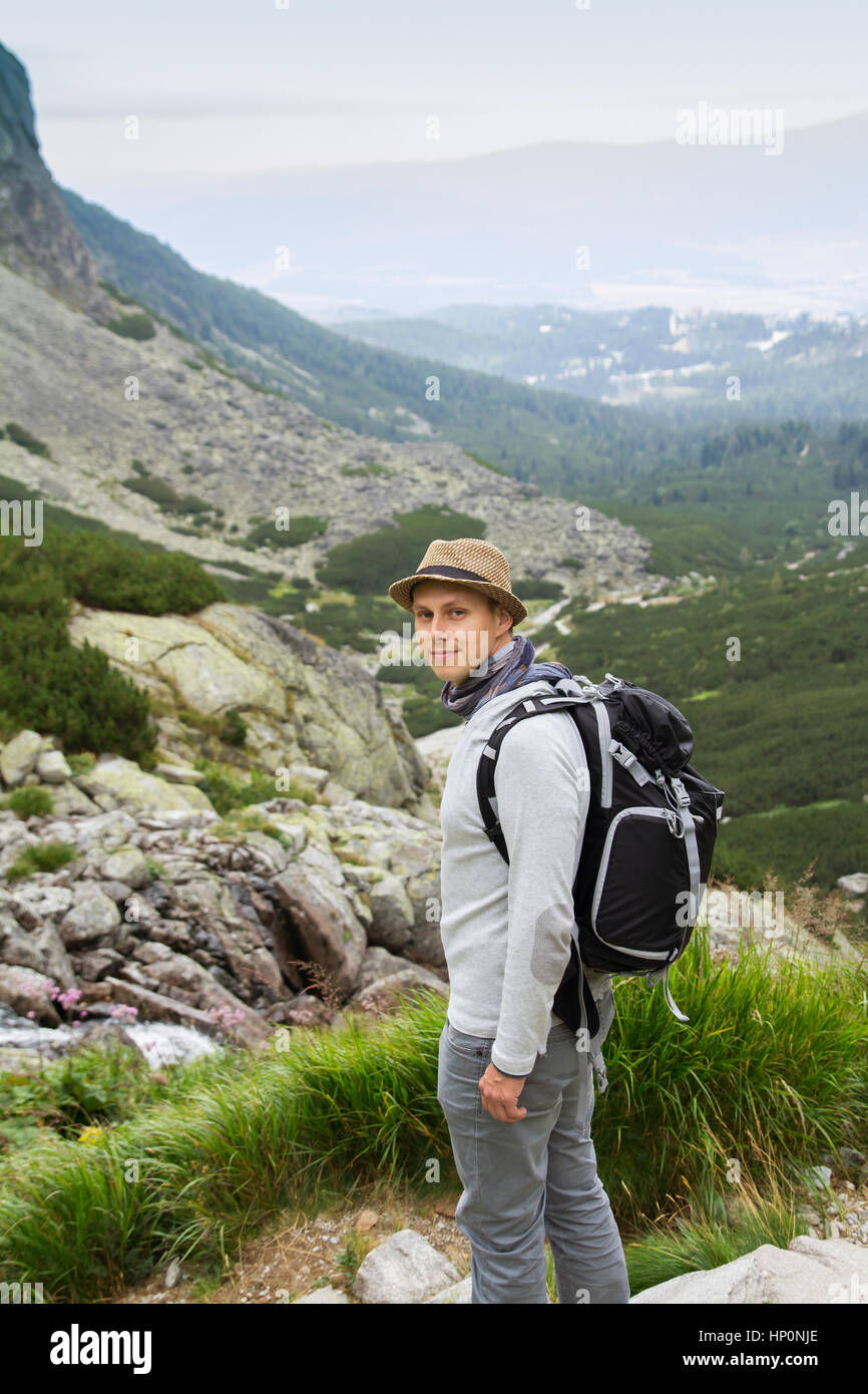 Jeune homme avec sac à dos randonnée en montagne Banque D'Images