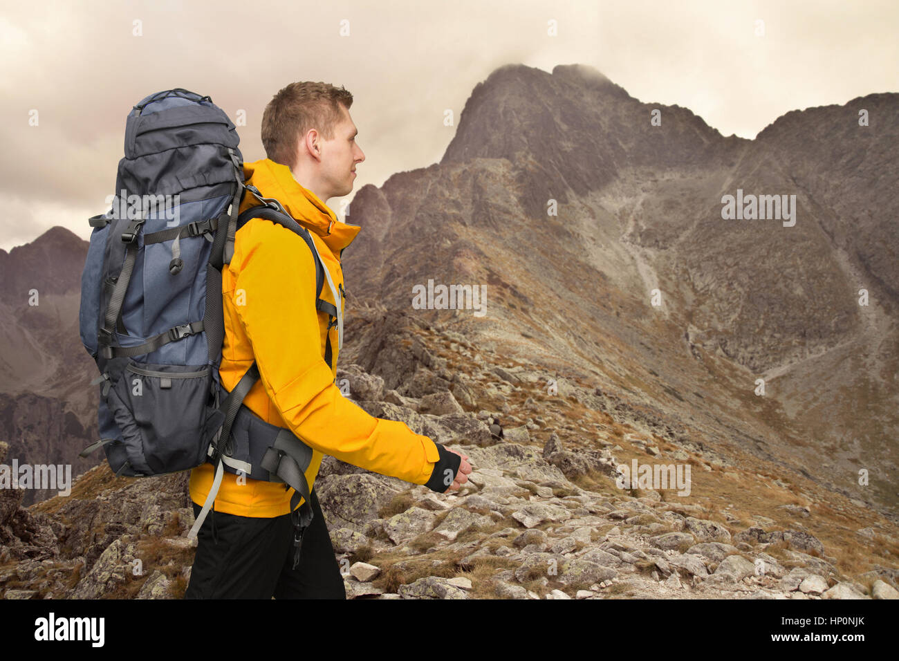 L'homme avec un grand sac à dos des randonneurs en montagne Banque D'Images
