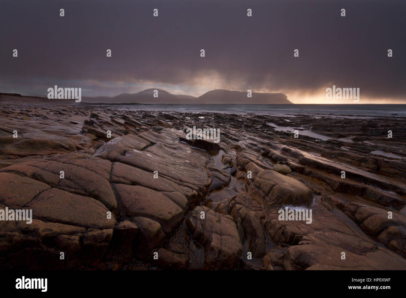 Averses de pluie et de grêle à Warebeth plage rocheuse sur îles Orkney Banque D'Images