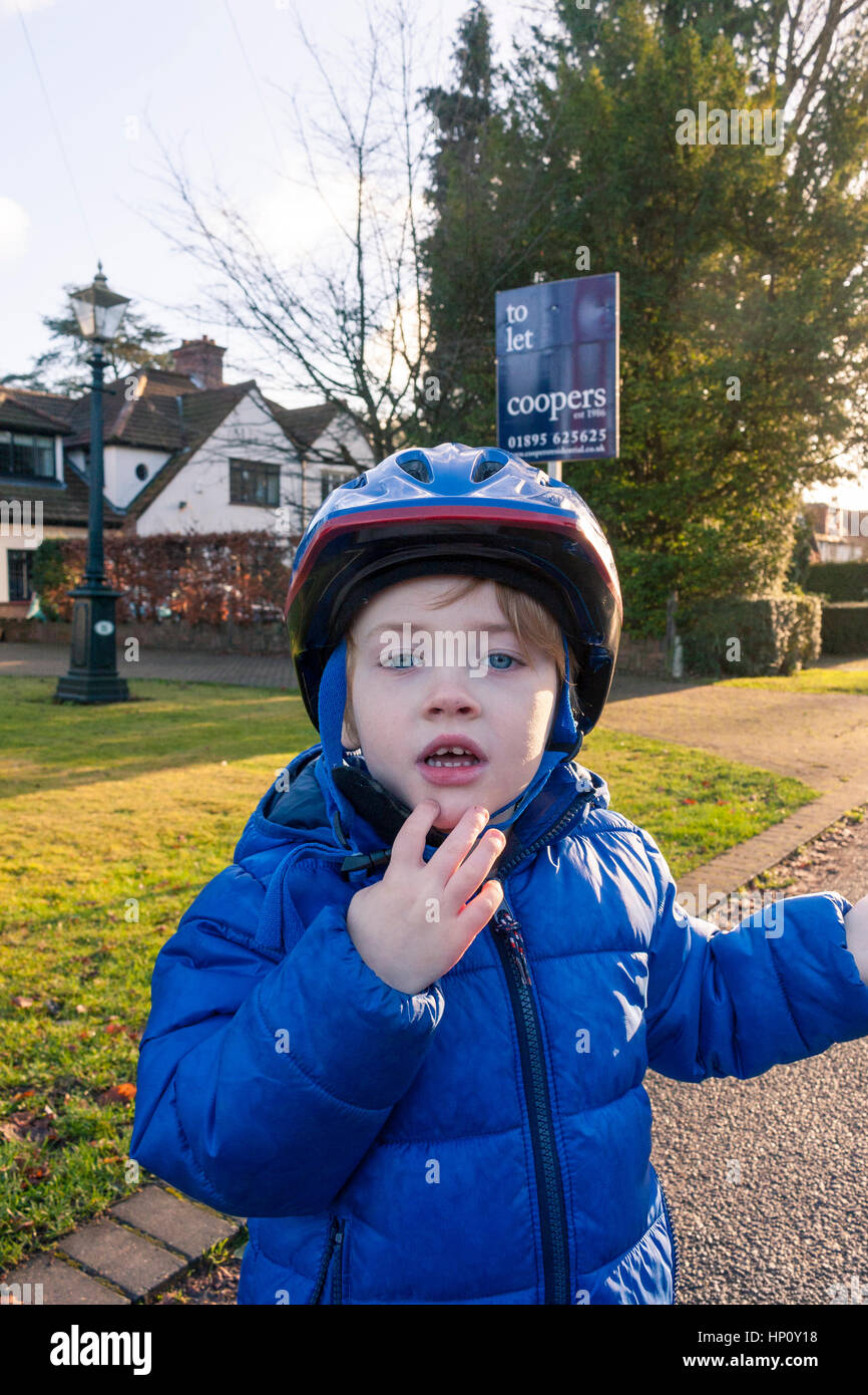 Un jeune garçon dans le bleu casque de vélo Banque D'Images