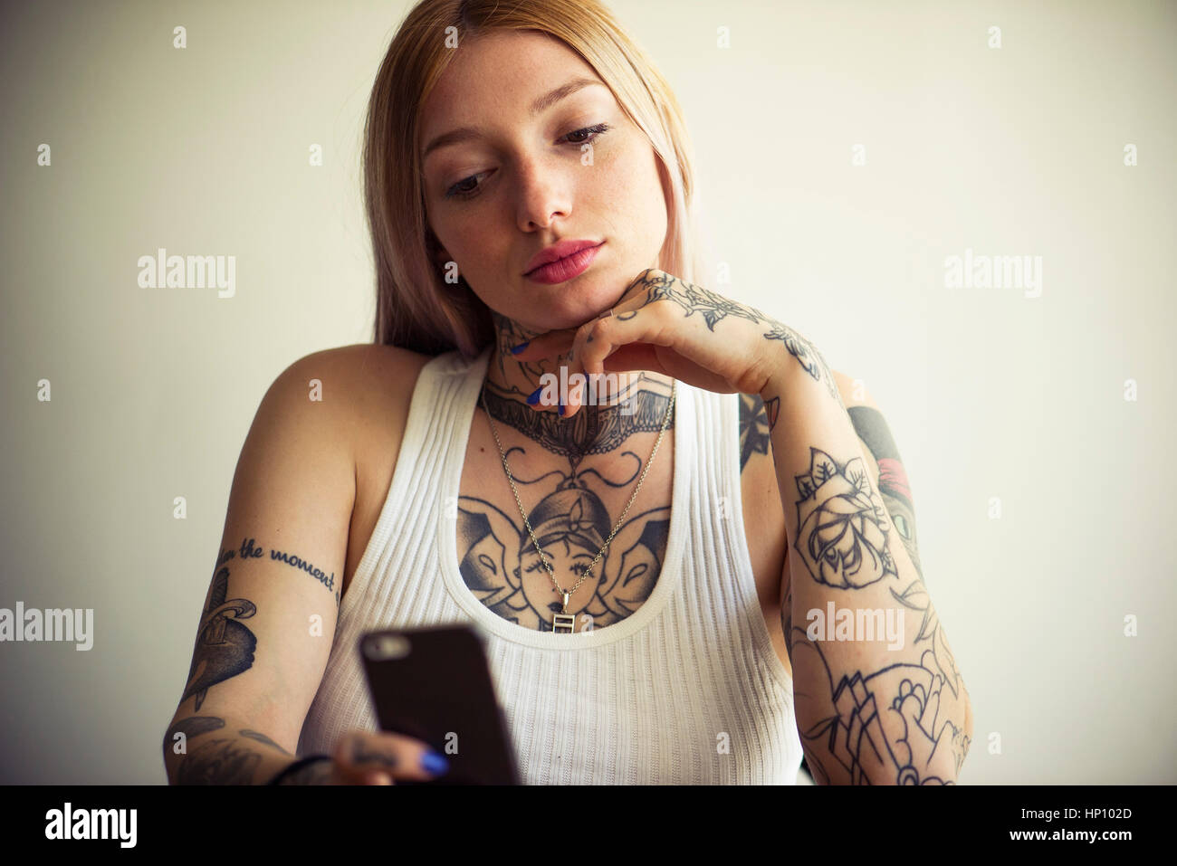 Tattooed Woman using smartphone Banque D'Images