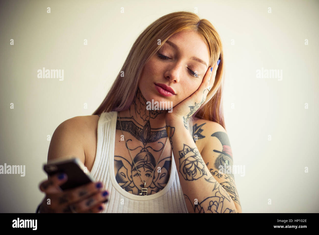 Tattooed Woman using smartphone Banque D'Images