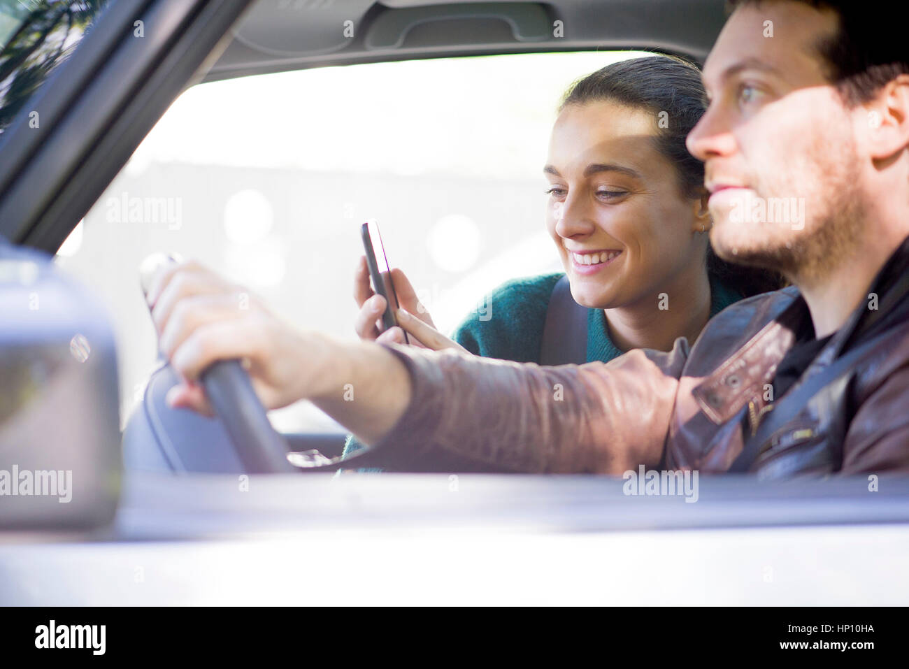 Couple d'écouter de la musique en streaming sur smartphone lors de road trip Banque D'Images