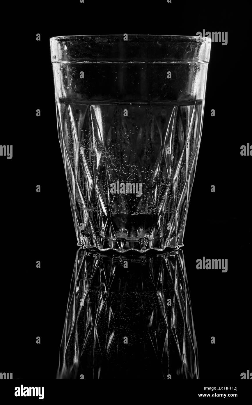 L'eau sur un verre sur fond sombre. Banque D'Images