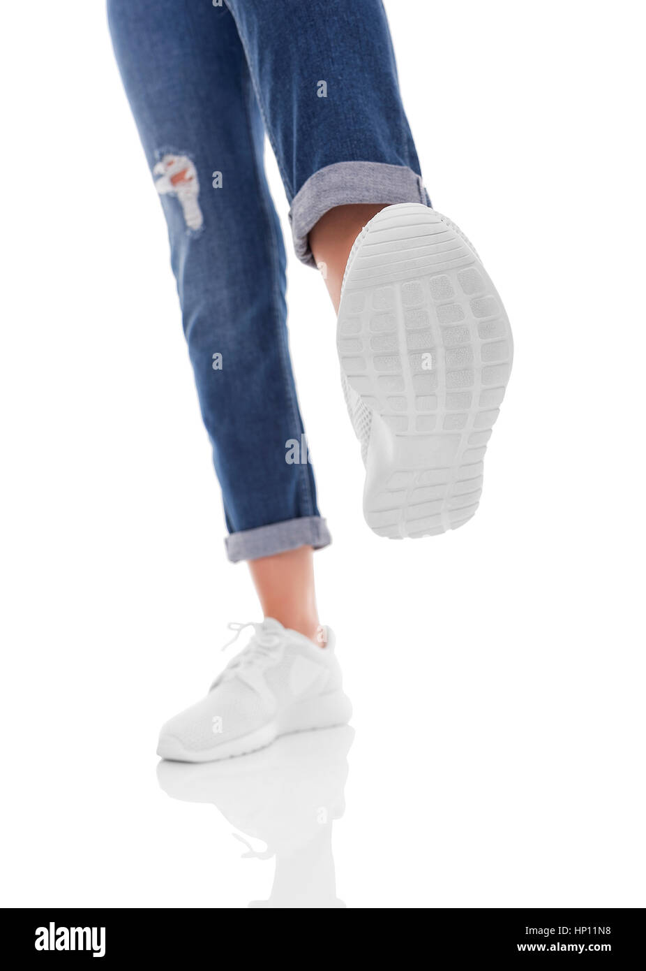 Les pieds de sneakers veulent quelque chose de piétiner. L'isolement sur un fond blanc. Banque D'Images