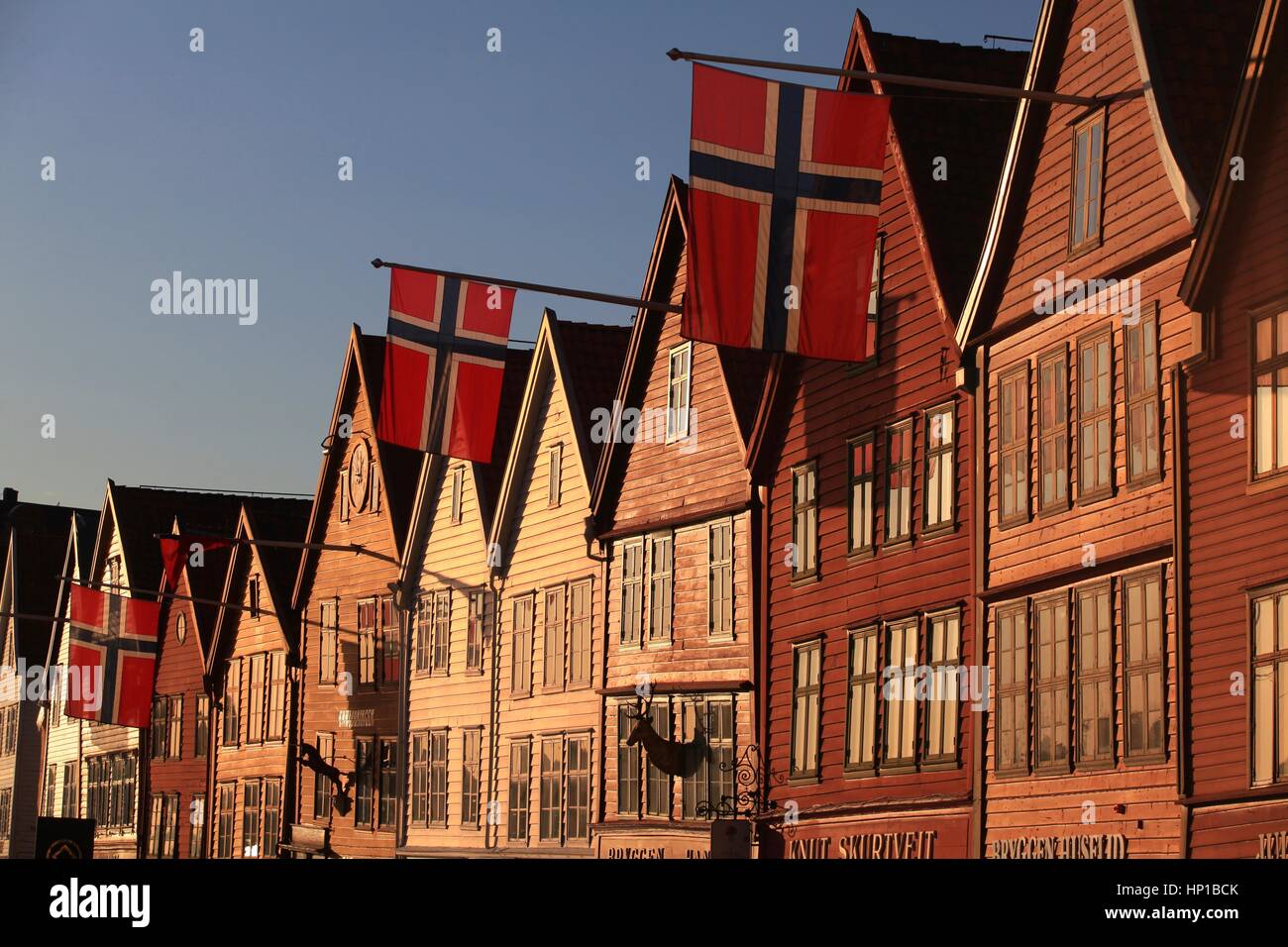 L'Entrepôts hanséatique Bryggen à Bergen, Norvège Norvégien avec les drapeaux sur jour de mai. La fin de l'après-midi la lumière reflétée dans les fenêtres ; drapeaux flottants. Banque D'Images L'Entrepôts hanséatique Bryggen à Bergen, Norvège Norvégien avec les drapeaux sur jour de mai. La fin de l'après-midi la lumière reflétée dans les fenêtres ; drapeaux flottants. Banque D'Images