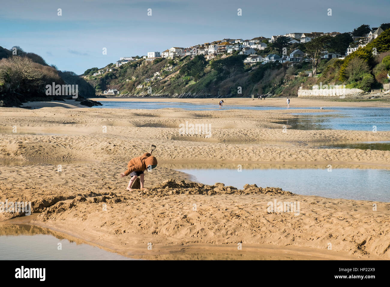 Un jeune garçon à creuser dans le sable à marée basse sur l'estuaire Gannel. Newquay, Cornwall, UK. Banque D'Images