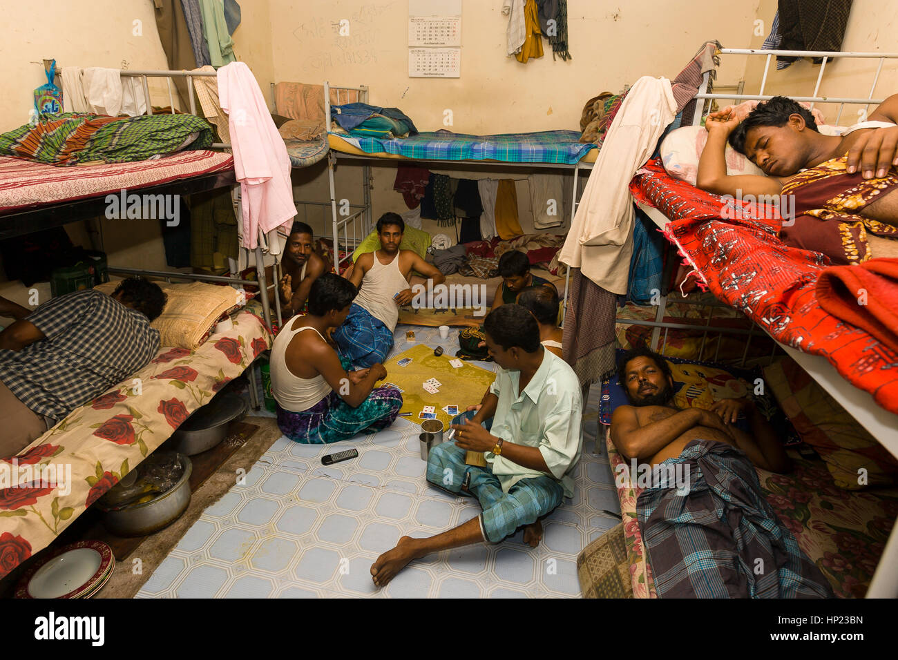 SHARJAH, EMIRATS ARABES UNIS - South Asian men jouer aux cartes et nap entre les quarts de travail, à un camp de travail dans la ville de Sharjah, 10km au nord-est de Dubaï. Banque D'Images