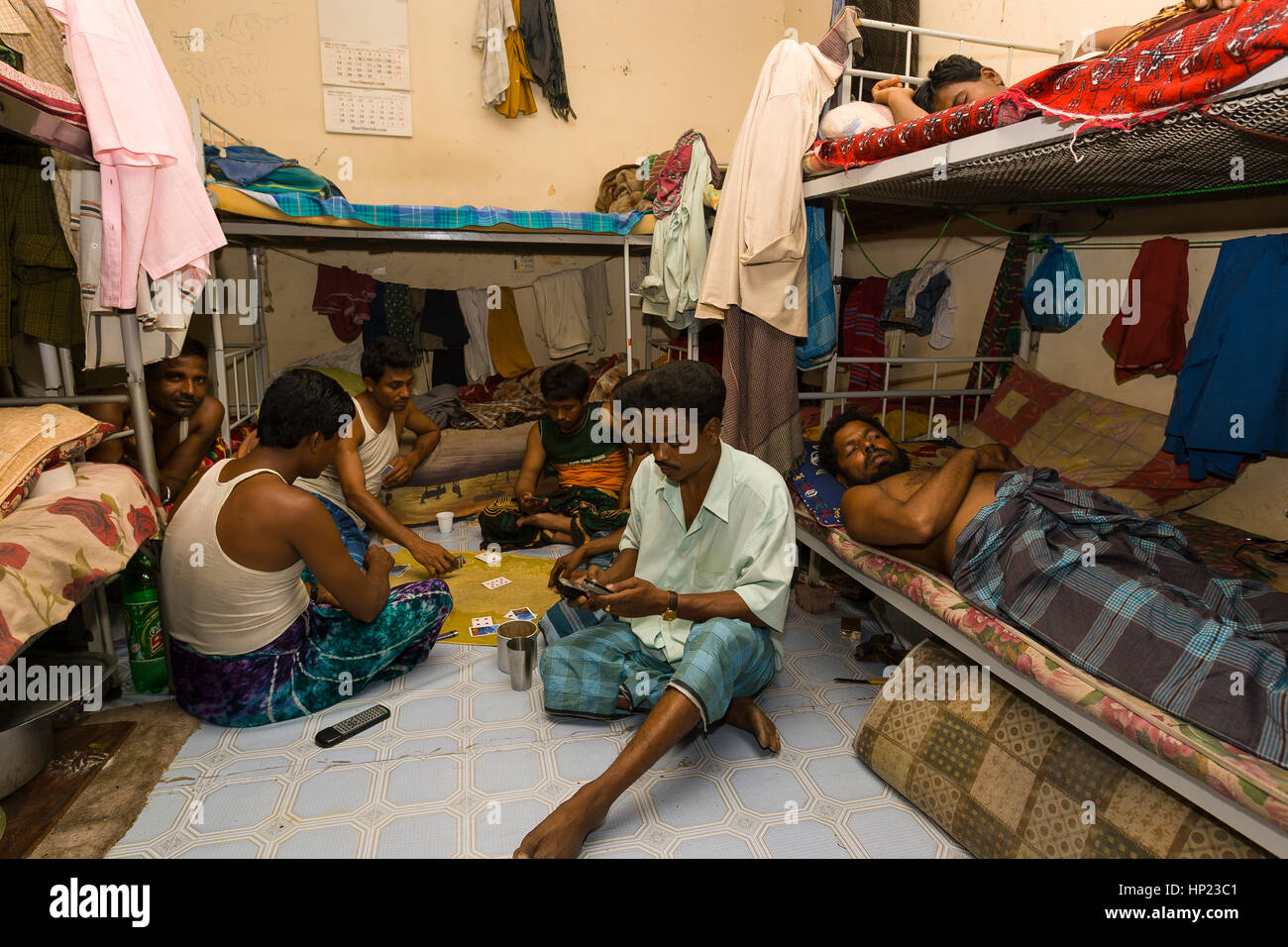 SHARJAH, EMIRATS ARABES UNIS - South Asian men jouer aux cartes et nap entre les quarts de travail, à un camp de travail dans la ville de Sharjah, 10km au nord-est de Dubaï. Banque D'Images