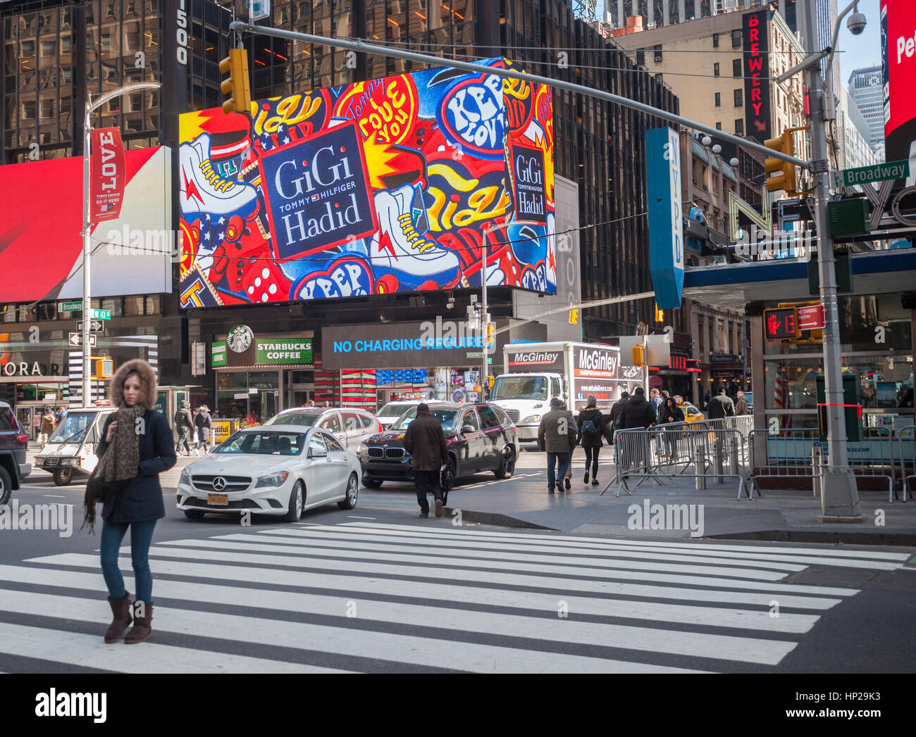 Les piétons traversent Broadway à Times Square à New York, le jeudi 16  février 2017, en face d'une publicité pour la Tommy Hilfiger/Gigi Hadid la  collaboration. Hilfiger n'a pas montré cette année