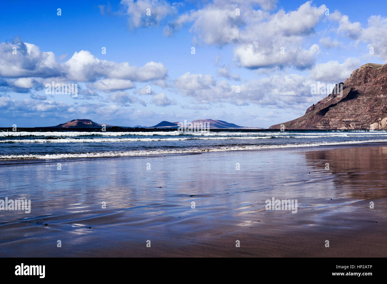 Une vue de la plage de Famara Lanzarote, Canaries, Espagne, avec le massif de Famara à droite et La Graciosa island dans l'arrière-plan Banque D'Images